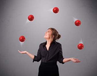 pretty young girl standing and juggling with red balls